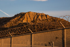 Chain link fence with barren mountain in background