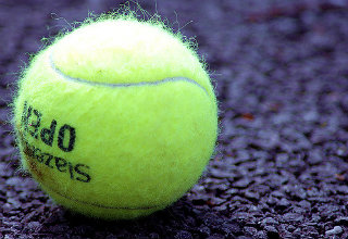 tennis ball on black gravel