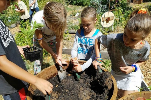 students learn about compost at school garden