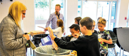 Students wait in line to scrape uneaten food into bins